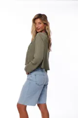 Blusa color verde militar, de corte crop y mangas largas, con escote en V con lazos y bordados en el frente.