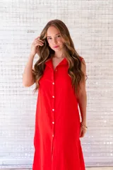 Camisola roja tipo vestido camisero, de corte midi, con cuello camisero, abotonada al frente y con abertura en el ruedo.