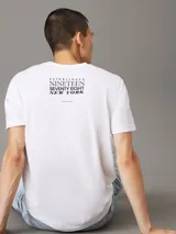 Remera blanca de algodón con cuello redondo, corte regular, mangas cortas y logo de Calvin Klein bordado en el pecho.