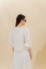Blusa color beige de lino 100% con mangas balloon y detalle de tablón en el hombro. Tiene mangas largas con detalle de 2 pespuntes elásticos en contratono, el recurso del elástico es ideal para remangarse la manga generar más volumen. Calce recto, largo por arriba de la cadera.