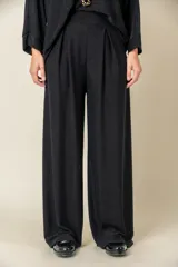 Pantalón italiano de lurex negro, de corte ancho con tablas en la parte frontal.