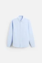 Camisa azul marino de corte regular fit, confeccionada en tejido de algodón Oxford. Tiene cuello abotonado, manga larga con puños abotonados, bolsillo de parche en el pecho y cierre frontal con botones.