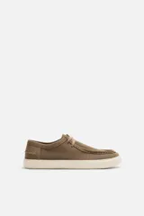 Zapato casual marrón de piel serraje con cordones, detalle de bordón en el empeine y suela a contraste.