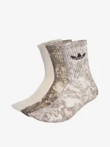 Pack de tres pares de calcetines Adidas a media pantorrilla. Un par liso color beige, un par con diseño tie-dye en tonos marrones y un par con diseño a rayas verticales en tonos marrones y logo del trifolio en negro.