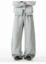 Pantalón de jogging gris de algodón, corte ancho (baggy) y tiro alto, con costura central vertical que recorre la pierna.