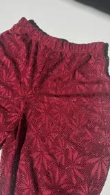 Pantalón acampanado de encaje color borgoña con diseño floral.