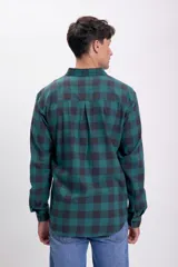 Camisa de cuadros en tonos azul marino y beige, de manga larga y cuello clásico.