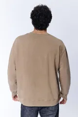 Buzo deportivo color visón con cuello redondo y mangas largas.