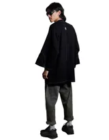 Kimono de denim negro lavado, de manga corta ancha y corte recto. Se cierra al frente con un broche metálico rectangular.