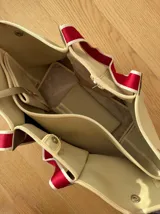 Bolso negro tipo tote de neopreno con bolsillo interno de red, sobre haciendo juego y gancho para sujetarlo.