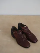 Sandalias mallorquinas de gamuza color verde azulado con tiras entrecruzadas y hebilla dorada al tobillo.