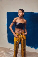 Pantalón acampanado de cuero sintético con estampado de piel de serpiente en tonos azules.