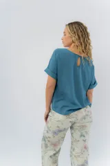 Remera blanca de viscosa liviana, con escote redondo y mangas cortas con vuelta.