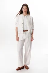 Pantalón de lino color blanco, tiro alto, corte recto y holgado, con pinzas delanteras y pespuntes a contratono.