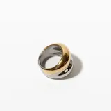 Anillo de acero enchapado, con diseño abultado bicolor: dorado en la parte superior y plateado en la inferior.