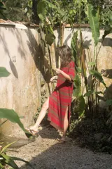 Vestido tejido artesanalmente a rayas horizontales color marrón y rojo, con mangas cortas y corte holgado.