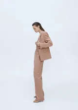 Pantalón de vestir color beige, de corte recto y tiro alto. Confeccionado en mezcla de lana con forro interior, cierre oculto de botón, gancho y cremallera, y dos bolsillos laterales.