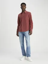 Pantalón de jean celeste de corte slim recto, con tiro medio, cinco bolsillos y cierre con cremallera.