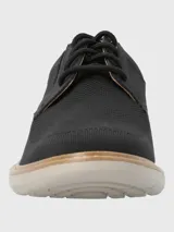 Zapato de vestir negro con capellada de cuero y tejido sintético, con cordones y suela de goma color crema.