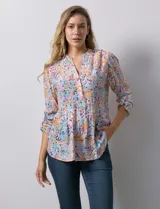 Blusa de gasa estampada con cuello a la base, escote en V y botones. Delantera con detalle plisado y largo de manga regulable con presilla y botón.