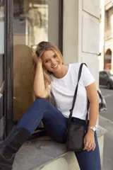 Bolso bandolera pequeño de cuero negro, ideal para llevar el móvil, tarjetas y maquillaje. Cuenta con cierre superior, bolsillo interno, bolsillo externo y correa ajustable.