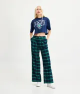 Pantalón de corte wide leg con estampado de cuadros en tonos azul y verde. Presenta pliegues en la cintura y trabillas para cinturón.