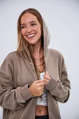 Cardigan con capucha color beige, con cierre frontal, efecto desgastado y puños acanalados.