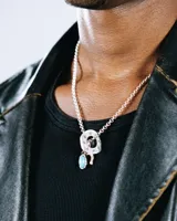 Collar de plata de ley 925 con cadena de eslabones finos y tres dijes colgantes: una piedra turquesa ovalada, una herradura y un sombrero de vaquero. El acabado es una combinación de pulido brillante y oxidado.