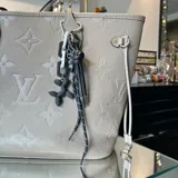 Charm para cartera o llavero con dije de perro inflable negro, sogas blancas y negras y mosquetón plateado.