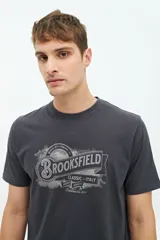 Remera gris de manga corta con cuello redondo y estampado frontal con el logo de la marca Brookfield.