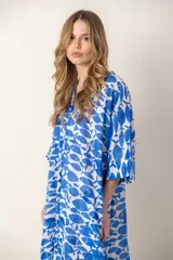 Vestido largo con estampado de peces azules sobre fondo blanco, cuello en V y mangas cortas.