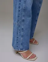 Jean de tiro alto de calce relajado, color azul denim. Tiene pretina con pasadores, botón y cierre. Delantera y trasera con bolsillos. Recortes verticales en el frente y recorte horizontal en el ruedo.