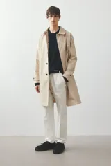 Pantalón de vestir color crema, de corte recto, con bolsillos laterales y traseros. Se ajusta a la cintura con botón.