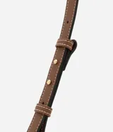 Cartera baguette mediana de poliuretano y poliéster, con estampado de rayas verticales en tonos crudo y blanco. Tiene cierre de cremallera, asa de mano ajustable y forro interior de poliéster.