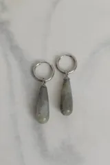 Par de aros colgantes con argolla de acero quirúrgico hipoalergénico y dije en forma de gota de piedra natural color marrón.