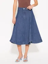 Pollera larga de denim azul con textura en relieve y desgastes, corte acampanado y calce a la cintura.