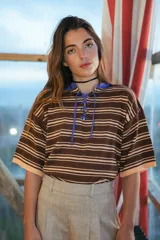 Camiseta de hilo de algodón a rayas horizontales marrones y beige, con calado sutil y escote acordonado con cordón azul.