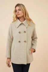 Chaquetón de lana fina color beige con cuello solapa, doble abotonadura frontal, bolsillos ojal y forro al tono.