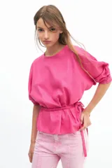 Blusa color fucsia con mangas tres cuartos abullonadas y lazo en la cintura.