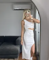 Vestido midi negro con corte asimétrico, una manga, abertura lateral y frunce en la cintura.
