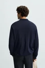 Polo de manga larga color negro, tejido en hilatura con mezcla de algodón y seda, de corte regular fit, con cuello solapa y cierre frontal de botonadura.