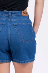 Short de jean de tiro alto, color azul medio, con bolsillos delanteros y traseros, y ruedo desflecado.