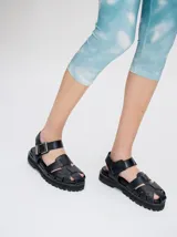 Sandalias romanas color verde oliva, con tiras entrecruzadas y hebilla lateral. Suela de goma negra con plataforma de 3cm. Fabricadas en cuero vacuno.