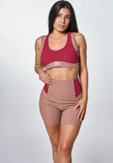 Conjunto deportivo marrón con detalles en color borgoña, compuesto por un top deportivo con logo "bk." y unos shorts de ciclista de tiro alto.