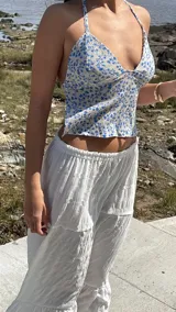 Top blanco con estampado de flores azules, escote halter y espalda descubierta.