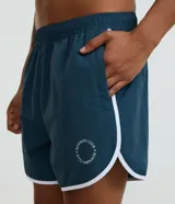 Bermuda deportiva para hombre de color azul, confeccionada en poliamida de secado rápido. Presenta cintura elástica con cordón ajustable, bolsillos funcionales y detalles laterales en blanco con estampa de lettering.