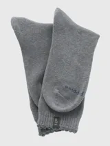 Calcetín de mujer de tejido grueso, largo medio, color gris jaspeado, con puño suave y etiqueta con logo en el borde superior.