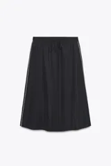Falda midi negra de tiro alto con cintura elástica ajustable con cordones y detalle de vivo lateral blanco a contraste.