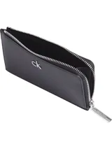 Tarjetero Calvin Klein de cuero sintético negro con cierre de cremallera y logo metálico plateado. Incluye múltiples ranuras para tarjetas y cadena adicional.