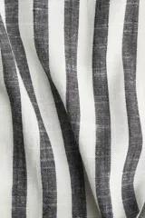 Pantalón de corte holgado en mezcla de viscosa y lino, con cintura elástica, cordón para ajustar y piernas amplias extralargas. Diseño a rayas verticales blancas y negras.